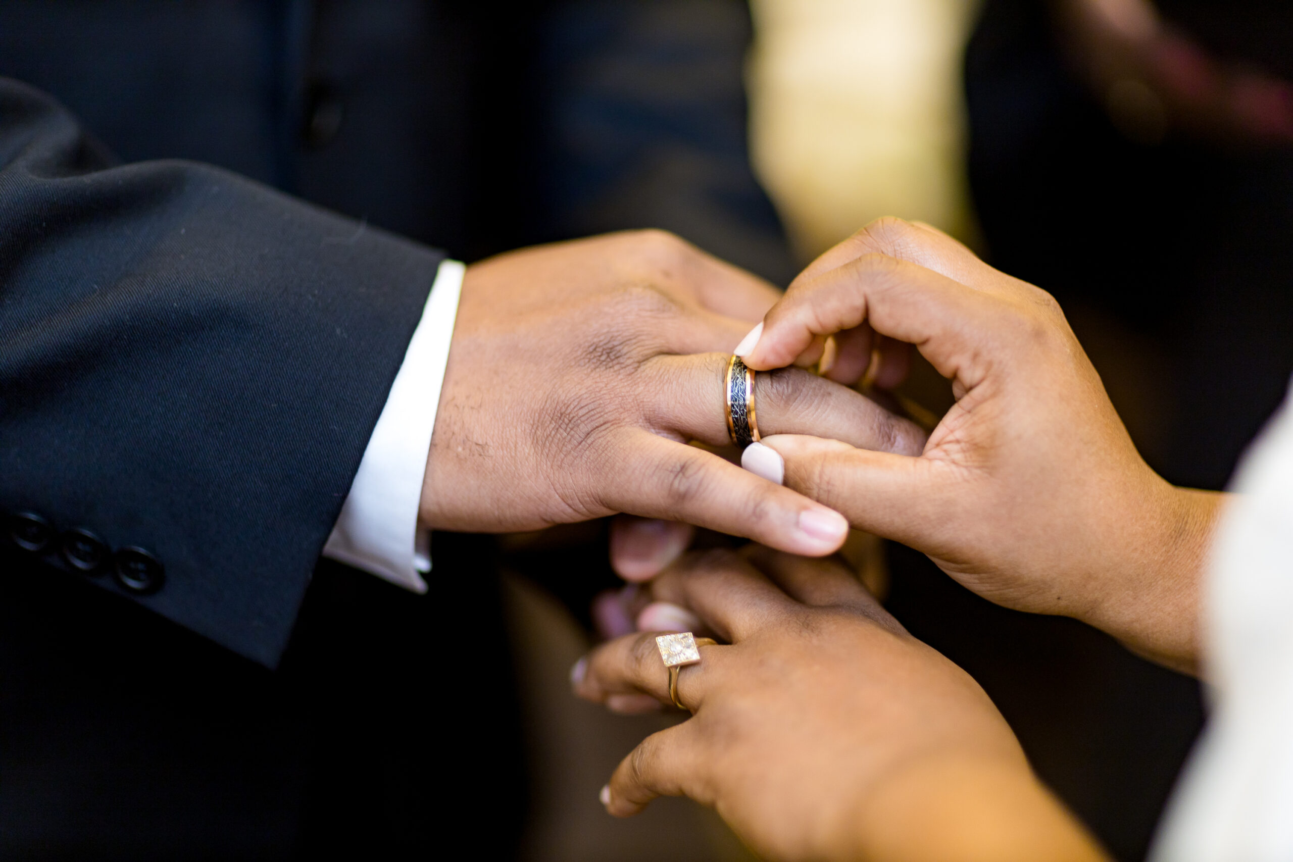 Wedding rings on two black hands during the ceremony